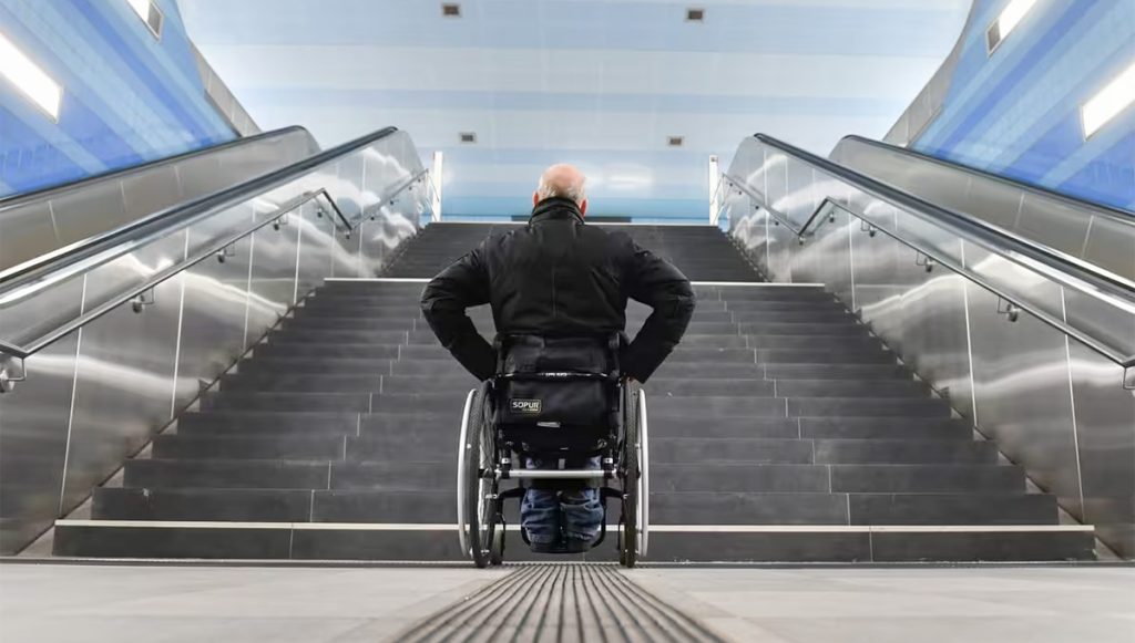 Les difficultés quotidienns des personnes handicapées : Un homme en fauteuil face à des escaliers. © Franck May / Picture Alliance