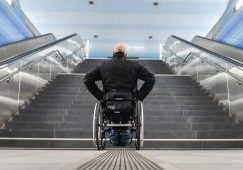 Les difficultés quotidienns des personnes handicapées : Un homme en fauteuil face à des escaliers. © Franck May / Picture Alliance